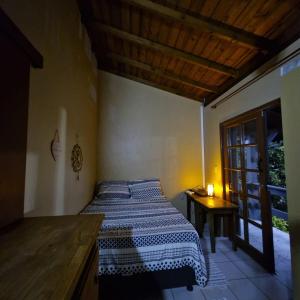 ガロパバにあるDescanso na Praiaのベッドとテーブルと窓のある寝室