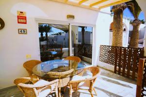a table and chairs on a balcony with palm trees at Casa del Capitan in Costa Calma