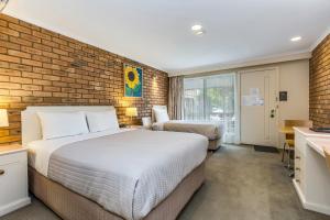 Postel nebo postele na pokoji v ubytování Golden Square Motor Inn