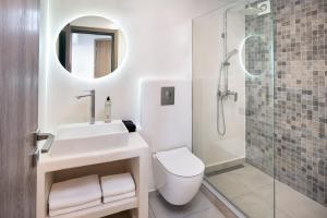 un bagno con wc, lavandino e doccia di Santorinn Suites Fira a Firà Altre 37 foto