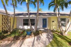 a house with palm trees in front of it at Thumb Point Oasis w Heated Pool walk to beach in Fort Pierce