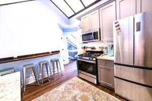 a kitchen with a stainless steel refrigerator and cabinets at Mandeville Creole Cottage - 3 bed-2 bath in New Orleans