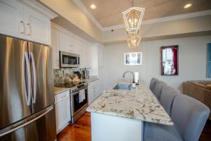 a kitchen with a stainless steel refrigerator and a counter at The Frenchman 2bed - 2 bath in New Orleans
