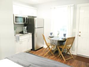 a kitchen with a table and a refrigerator at Charming St. Ann Studio in New Orleans