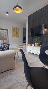 a living room with a couch and a table and chairs at Apartament Fajny Kąt in Ustrzyki Dolne