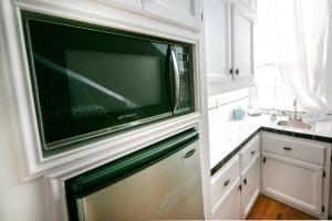 a kitchen with a large flat screen tv on a wall at Governors Mansion 5 bedroom-3 bath in New Orleans +38 photos