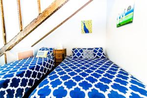two beds in a room with blue and white sheets at Historic Treme Creole Cottage 3 bed-2 bath (C) in New Orleans