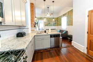 eine Küche mit weißen Schränken und Holzböden in der Unterkunft Ursulines Historic Creole Cottage- Steps to Qtr -E in New Orleans