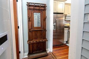 eine Holztür in einer Küche mit einem Kühlschrank in der Unterkunft Ursulines Historic Creole Cottage- Steps to Qtr -E in New Orleans