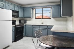 a kitchen with blue cabinets and a table with chairs at Melrose @ Seabrook, BW Signature Collection by Best Western in Seabrook