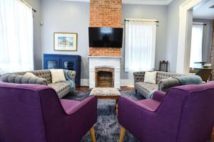 a living room with couches and a fireplace at Villere Historic Mansion in New Orleans