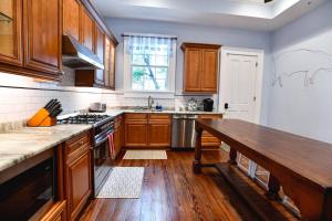 a kitchen with wooden cabinets and a wooden table at Villere Historic Mansion in New Orleans