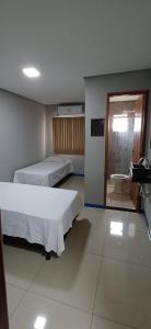 a room with two beds and a bathroom with a toilet at Brasil hotel in Canaã dos Carajás