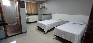 a hospital room with two beds and a bathroom at Brasil hotel in Canaã dos Carajás +3 photos
