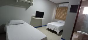 a hospital room with two beds and a tv at Brasil hotel in Canaã dos Carajás