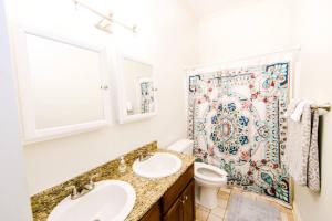 a bathroom with two sinks and a shower at Dumaine Cozy Home - 3 bed close to QTR in New Orleans +4 photos