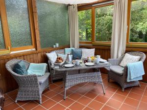 a porch with a table and chairs and windows at Christianes Apartment - Ebstorf in Ebstorf