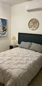 ein großes weißes Bett in einem Schlafzimmer mit einer Wand in der Unterkunft Agradable depto con estacionamiento y portón eléctrico in Guasave