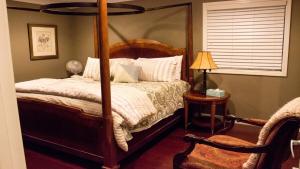 una camera da letto con un letto a baldacchino e una sedia di Hall of Fame Private Resort-9 Miles to Downtown Nashville Pools Arcade a Madison Altre 39 foto