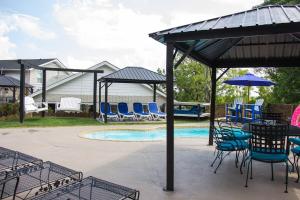un patio con sedie e ombrelloni accanto alla piscina di Hall of Fame Private Resort-9 Miles to Downtown Nashville Pools Arcade a Madison