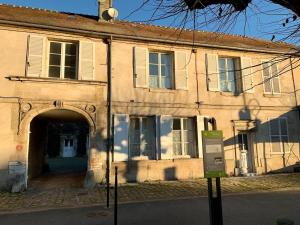 an old building with an archway in front of it at Au plus près du Chateau ! in Chantilly