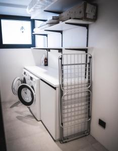 una lavanderia con lavatrice e finestra di Manu Apartments a Livigno