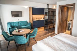 una stanza con un letto, un tavolo e delle sedie di Manu Apartments a Livigno Altre 60 foto