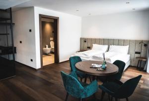 una stanza d'albergo con un letto, un tavolo e delle sedie di Manu Apartments a Livigno
