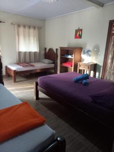a bedroom with two beds with purple sheets at Ocaso Cerrdo chalé in Alto Paraíso de Goiás
