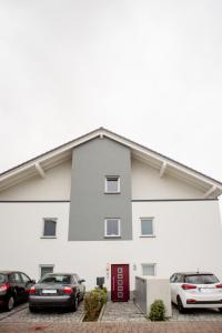 ein weißes Gebäude mit auf einem Parkplatz geparkten Autos in der Unterkunft Quiet Apartment - 74qm - 2 Bedrooms - 3 Beds in Limburg an der Lahn