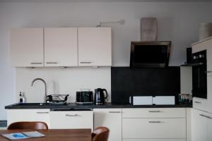 a kitchen with white cabinets and a black counter top at Quiet Apartment - 74qm - 2 Bedrooms - 3 Beds in Limburg an der Lahn