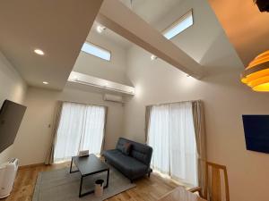 石垣岛I's villa 真栄里石垣島的客厅配有黑色沙发和2扇窗户