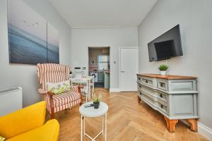 a living room with a couch and a tv at Dunluce Park 3 - Portrush by the Sea in Portrush