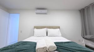 Un dormitorio con una cama con toallas. en Cobertura em Arraial do Cabo - Vista Mar, Piscina, Churrasqueira, 50m Praia, en Arraial do Cabo