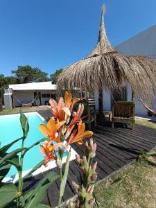 una terraza con una cabaña y una piscina en Solar de la Viuda, en Punta del Diablo