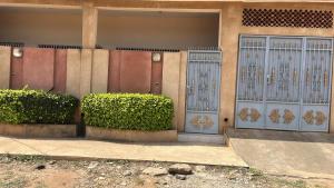 a building with two blue doors and some bushes at Les Résidences de Cobat in Kika