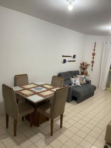 a living room with a table and a couch at Flat Brisa da BARRA in Barra de São Miguel