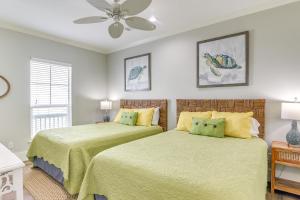 una camera da letto con due letti e un ventilatore a soffitto di Oceanfront Crystal Beach Vacation Home with Deck! a Crystal Beach