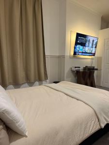 a bedroom with a white bed and a flat screen tv at City Centre Uni area PS4 Netflix in Neepsend