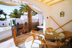 a balcony with a glass table and chairs at Casa del Capitan in Costa Calma