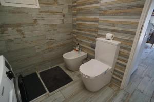 a bathroom with a toilet and wooden walls at Casa del Capitan in Costa Calma +31 photos