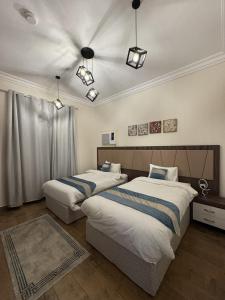 two beds in a hotel room with two at Hayatt Ula Suite - 104 in AlUla