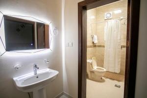 a bathroom with a sink and a toilet and a television at Hayatt Ula Suite - 104 in AlUla +13 photos