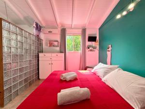 a bedroom with a large bed with two towels on it at Gîtes Les Bienheureux - Piscine, Hamak, Terrasse in Anse-Bertrand