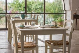 a table and chairs with plates and cups on them at Masseria Palombara Grande in Ostuni