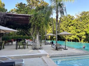 a swimming pool with tables and chairs next to a swimming pool at Golf & Beach Haven in Tulum