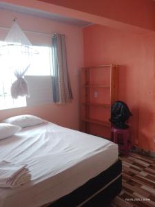 une chambre avec un grand lit et une fenêtre dans l'établissement Casa temporada Caípe, à São Francisco do Conde