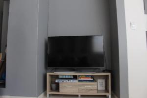 una TV a schermo piatto seduta su un supporto in legno di Acogedora Recamara Matrimonial con Blackout - A solo 2 cuadras del WTC! a Città del Messico