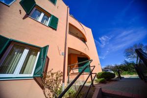 a brown building with green windows and a staircase at Apartments Ivan in Zadar