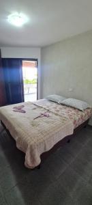 a bedroom with a large bed with a blanket at Vilarim Paraíso Costeiro Conforto e Piscina in Matinhos +1 photo